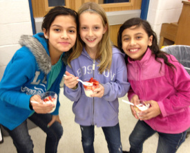 Three girls holding yogurt parfaits