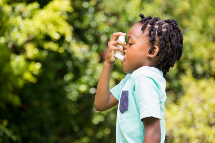 African American boy with inhaler outside 