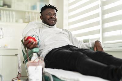 African American young man smiling while donating blood